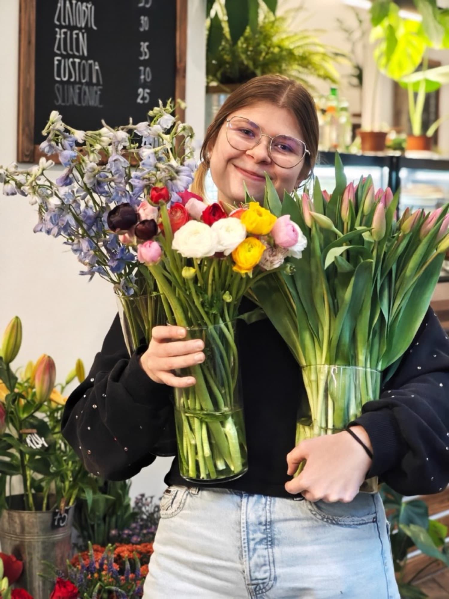 Florist with vases full of tulips and meadow flowers
