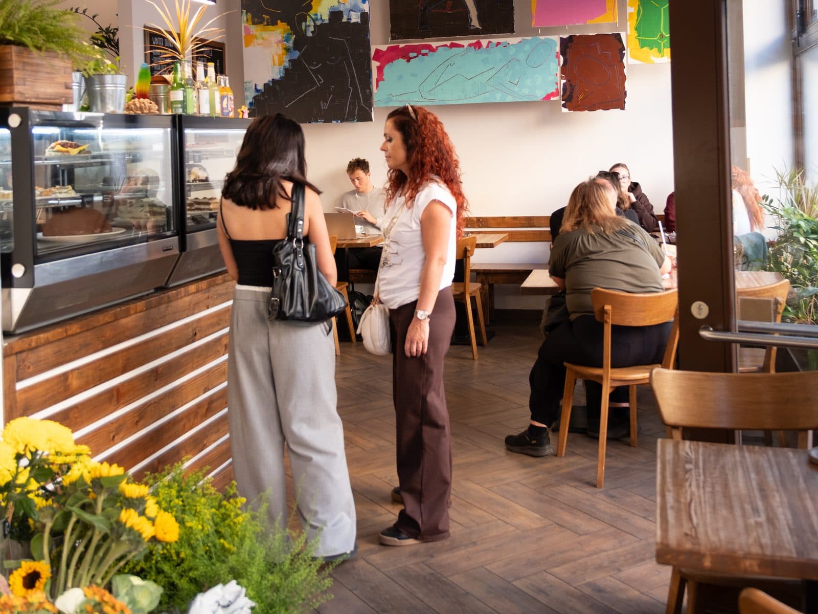 Guests at the cake counter, with tables and paintings behind them